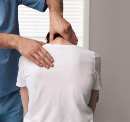 Pacjent podczas wizyty u ortopedy, który diagnozuje lordozę.