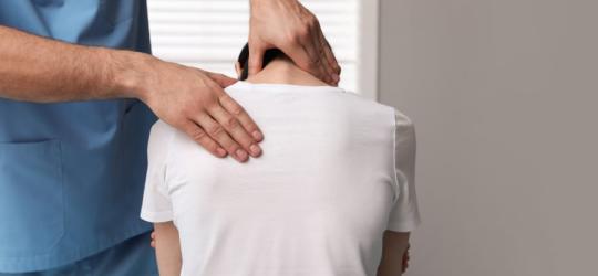 Pacjent podczas wizyty u ortopedy, który diagnozuje lordozę.