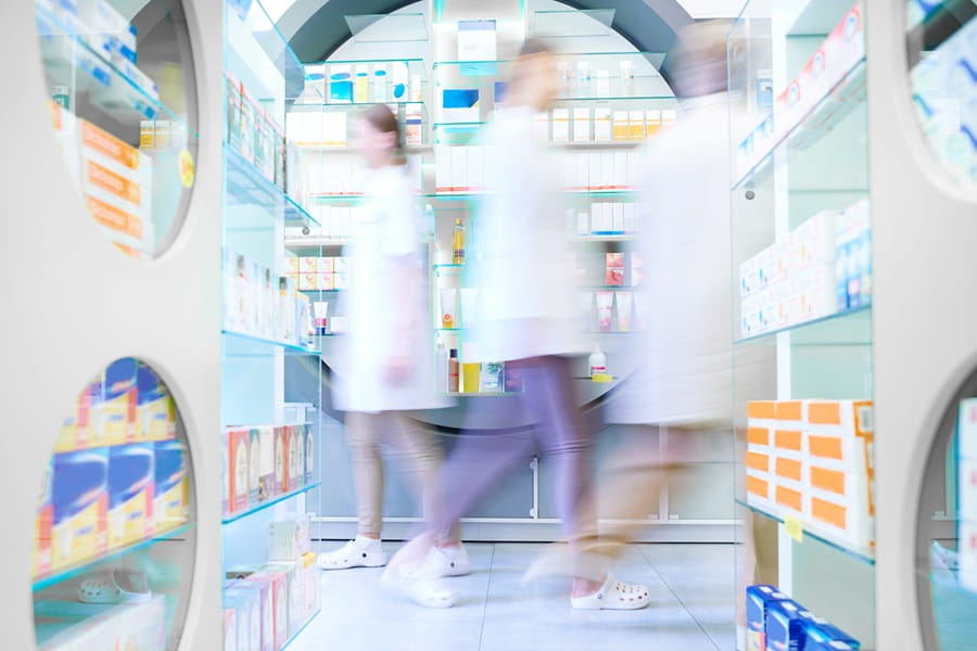 Farmaceuci poruszający się po aptece.