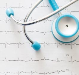 Stetoskop leżący na zapisie EKG, czyli elektrokardiogramie.