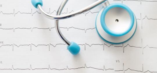 Stetoskop leżący na zapisie EKG, czyli elektrokardiogramie.