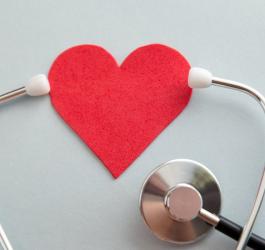 Stetoskop obejmujący słuchawkami serce wykonane z filcu.
