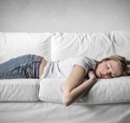 Kobieta cierpiąca na narkolepsję śpi na kanapie.