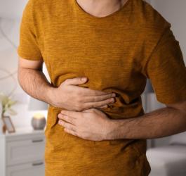Mężczyzna trzyma się za brzuch, doskwiera mu nerwica żołądka.