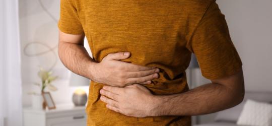 Mężczyzna trzyma się za brzuch, doskwiera mu nerwica żołądka.