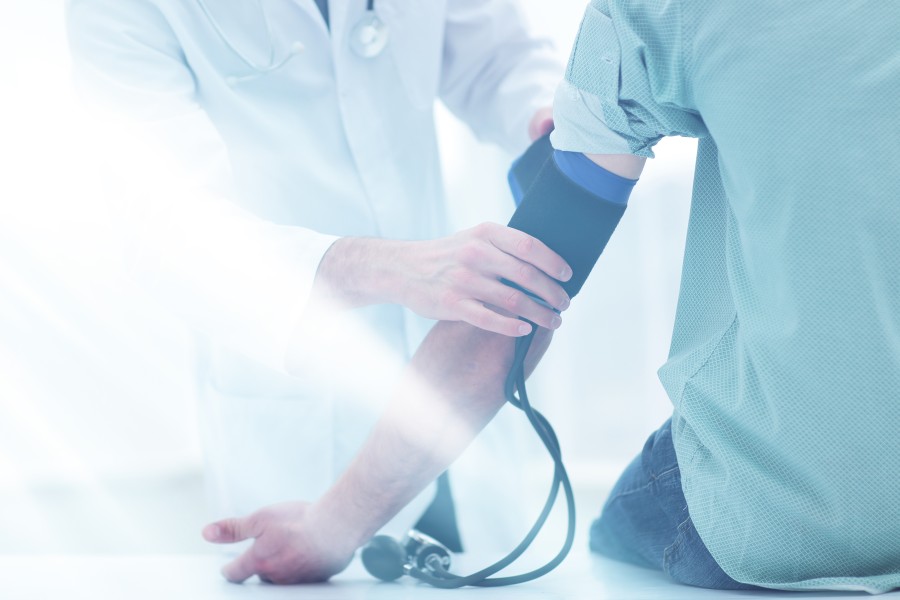 Mężczyzna ma mierzone ciśnienie u lekarza, by sprawdzić, co oznacza niskie ciśnienie i wysoki puls.