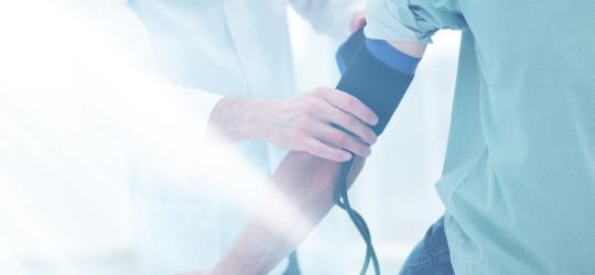 Mężczyzna ma mierzone ciśnienie u lekarza, by sprawdzić, co oznacza niskie ciśnienie i wysoki puls.