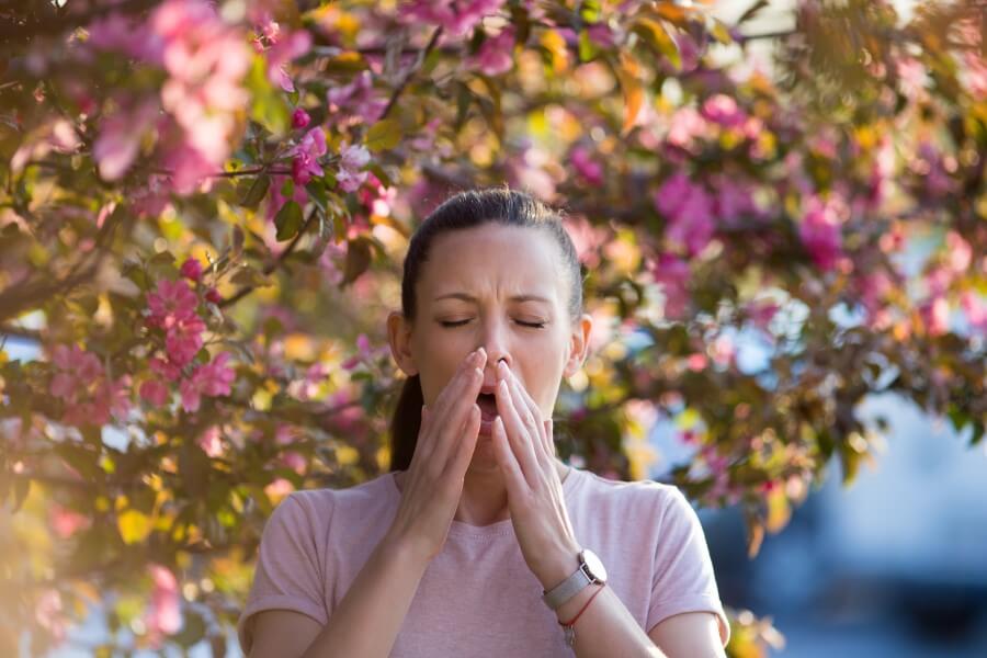 Kobieta cierpi na alergię na pyłki roślin, na którą mogłoby pomóc jej odczulanie.