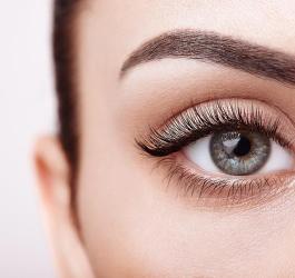 Zbliżenie na kobiece oko z pięknym wachlarzem długich rzęs.