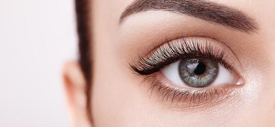 Zbliżenie na kobiece oko z pięknym wachlarzem długich rzęs.