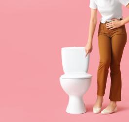 Kobieta wskazuje palcem na toaletę.