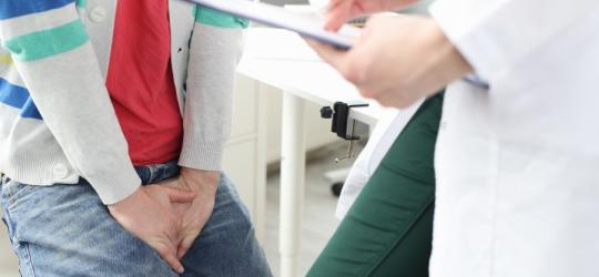 Mężczyzna podczas wizyty u urologa, jest w trakcie diagnostyki opryszczki narządów płciowych.