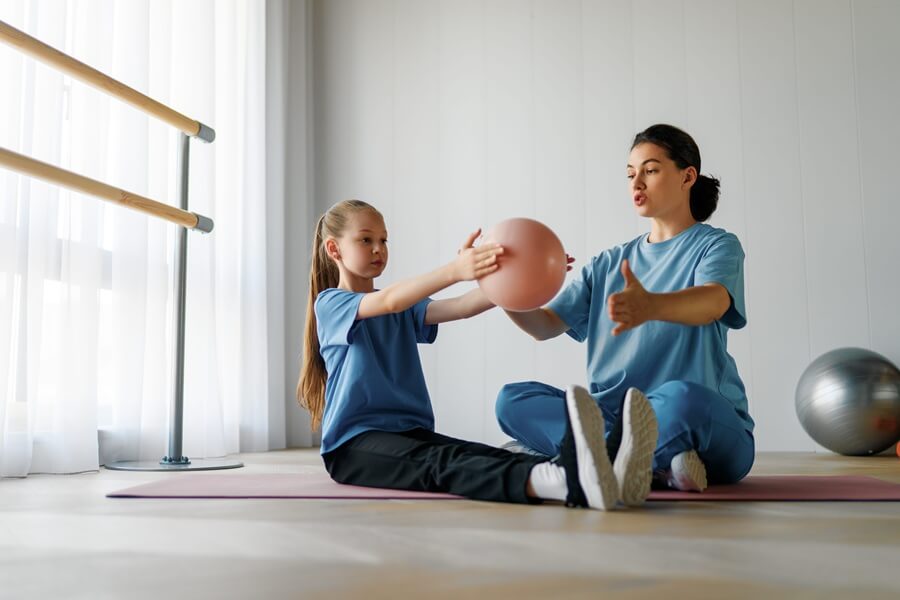 Dziewczynka z osteochondrozą podczas rehabilitacji z fizjoterapeutką.