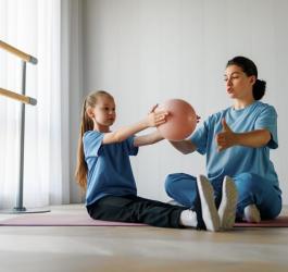 Dziewczynka z osteochondrozą podczas rehabilitacji z fizjoterapeutką.