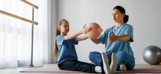 Dziewczynka z osteochondrozą podczas rehabilitacji z fizjoterapeutką.