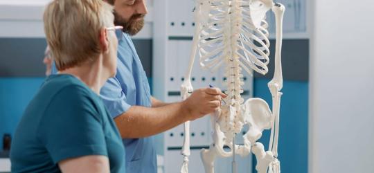 Lekarz tłumaczy pacjentce, czym jest osteomalacja.