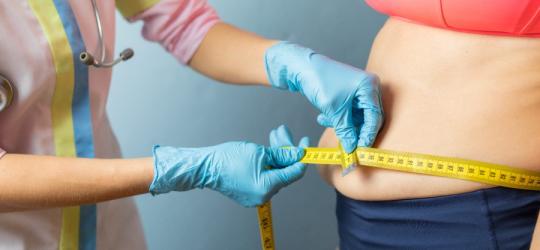 Kobieta z otyłością brzuszną podczas badania u lekarza.