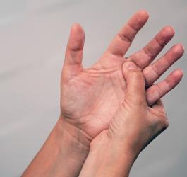 Mężczyzna chwyta się za lewą dłoń, męczą go parestezje.