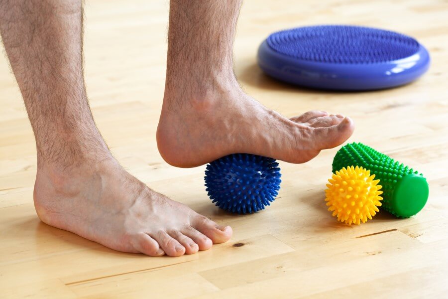 Mężczyzna wykonuje ćwiczenia na płaskostopie.