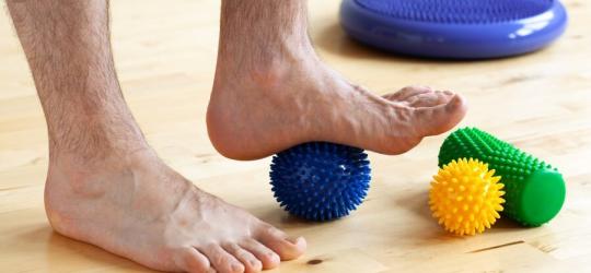 Mężczyzna wykonuje ćwiczenia na płaskostopie.