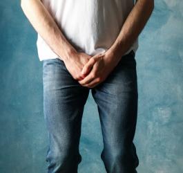 Mężczyzna trzyma się za okolice krocza.