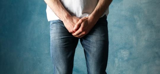 Mężczyzna trzyma się za okolice krocza.