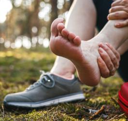 Kobieta skręciła kostkę podczas treningu na świeżym powietrzu. Skręcona kostka wymaga opatrzenia.