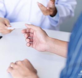 Lekarz wręcza pacjentce receptę. W prawym rogu logo SCZ Interior.