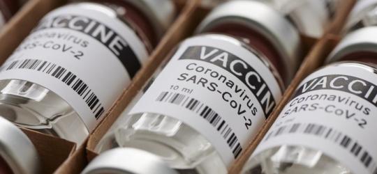 Tekturowe kartoniki, a w nich fiolki zawierające szczepionki przeciwko SARS-CoV-2.