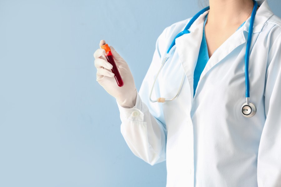 Lekarka trzyma w dłoni fiolkę z krwią pacjenta, przeznaczoną do testu OGGT czyli krzywej cukrowej.