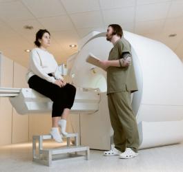 Technik tłumaczy pacjentce przebieg badania rezonansem magnetycznym.