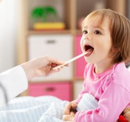 Dziewczynka podczas badania gardła u lekarza.