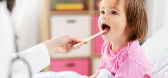 Dziewczynka podczas badania gardła u lekarza.