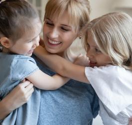 Szczęśliwa kobieta z dwiema małymi córkami.