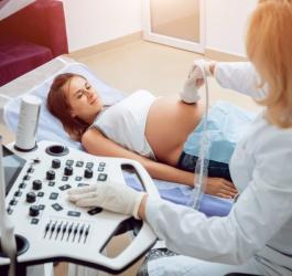 Pacjentka w trakcie wizyty u ginekolożki. Lekarka wykonuje USG w ciąży.
