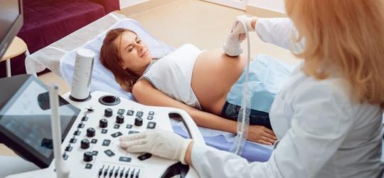 Pacjentka w trakcie wizyty u ginekolożki. Lekarka wykonuje USG w ciąży.