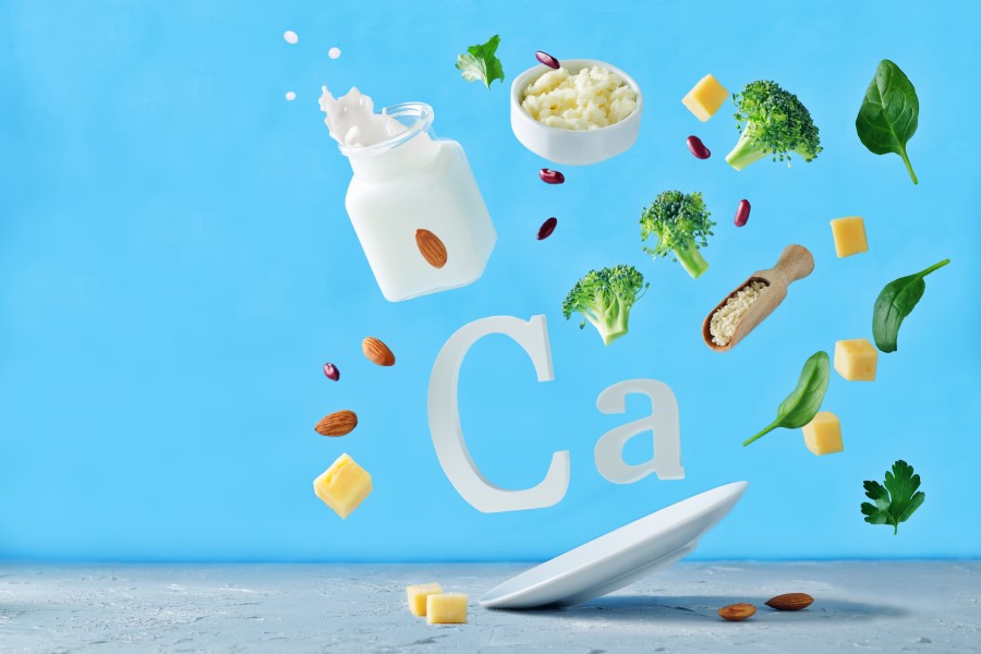 Symbol wapnia (Ca), wokół niego produkty spożywcze, które są źródłem wapnia w diecie.