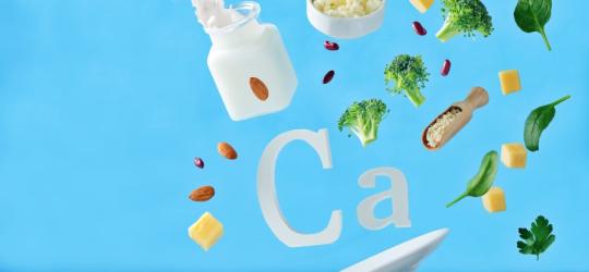Symbol wapnia (Ca), wokół niego produkty spożywcze, które są źródłem wapnia w diecie.