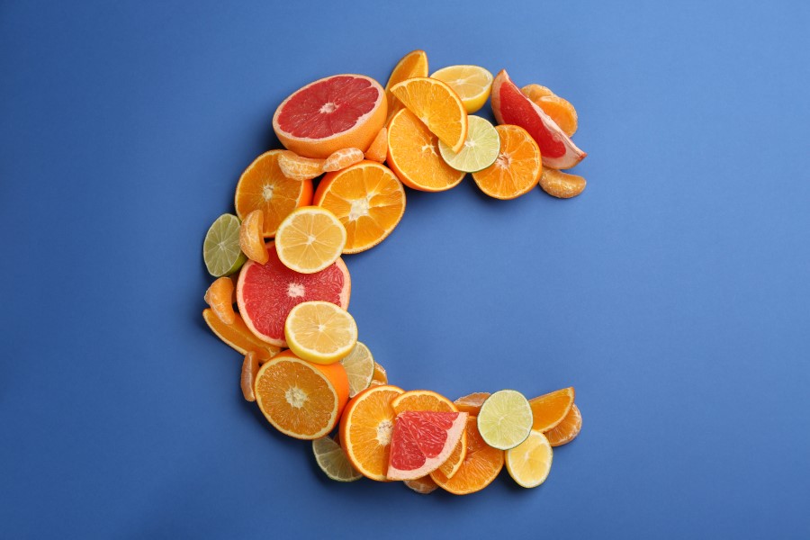 Przepołowione owoce cytrusowe ułożone w kształt litery C, symbolizującej witaminę C.