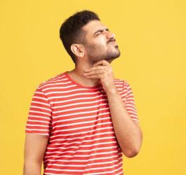 Mężczyzna chwyta się za gardło, doświadcza reakcji alergicznej grożącej wstrząsem anafilaktycznym.