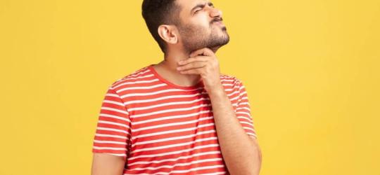 Mężczyzna chwyta się za gardło, doświadcza reakcji alergicznej grożącej wstrząsem anafilaktycznym.