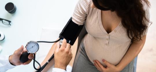 Kobieta w ciąży ma mierzone ciśnienie. Wysokie ciśnienie w ciąży stanowi duże zagrożenie.