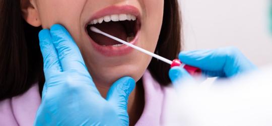 Kobieta ma pobierany wymaz z gardla.