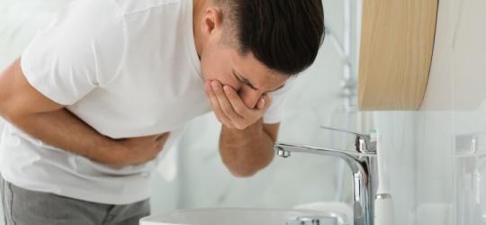 Mężczyznę męczą nudności, zaraz zwymiotuje do umywalki.