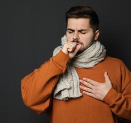 Mężczyzna jest chory, boli go gardło, zmaga się z zapaleniem nagłośni.