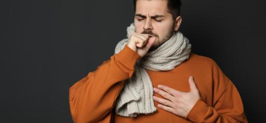 Mężczyzna jest chory, boli go gardło, zmaga się z zapaleniem nagłośni.