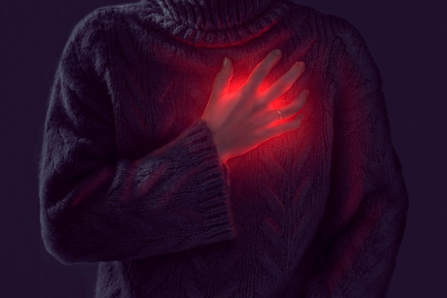 Kobieta trzyma się za klatkę piersiową, widoczny jest stan zapalny, sugerujący zapalenie osierdzia.