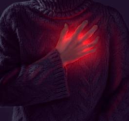 Kobieta trzyma się za klatkę piersiową, widoczny jest stan zapalny, sugerujący zapalenie osierdzia.