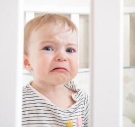 Płaczące niemowlę w łóżeczku.