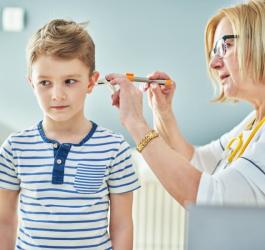 Lekarka diagnozuje zapalenie ucha u dziecka.